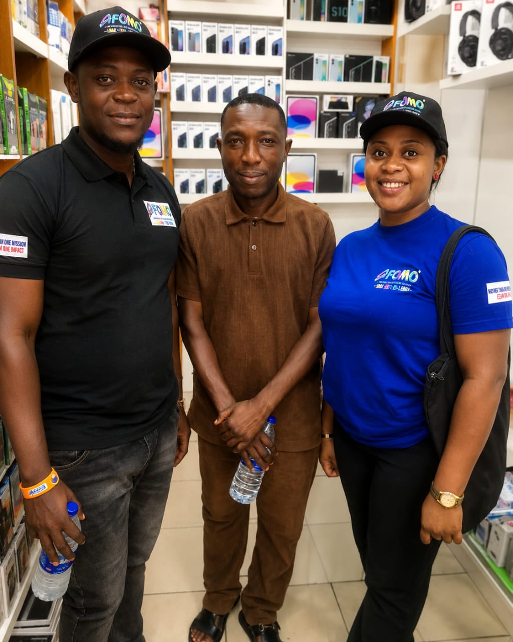 Afomo agents posing with a store owner at Banex Plaza